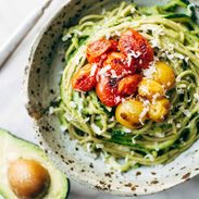 Zucchini spaghetti with tomato topping in a bowl.