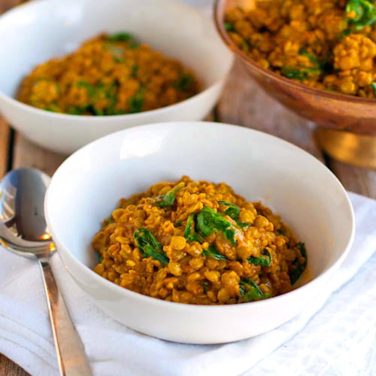 Coconut green curry lentils in a white bowl.